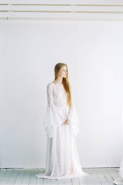 Güzel gelin beyaz minimalist zemin üzerinde. Güzel Sanatlar düğün hazırlıkları.