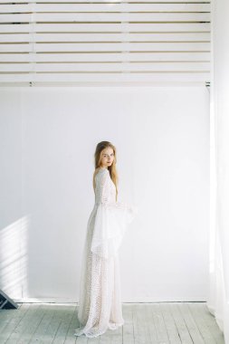 Güzel gelin beyaz minimalist zemin üzerinde. Güzel Sanatlar düğün hazırlıkları.