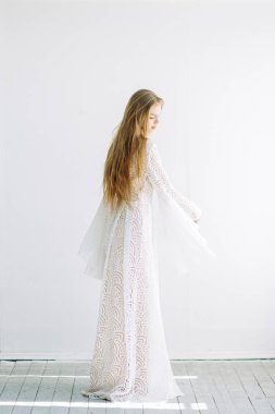 Güzel gelin beyaz minimalist zemin üzerinde. Güzel Sanatlar düğün hazırlıkları.