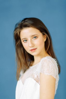 Parlak mavi ve kırmızı zemin üzerine güzel bir gelin portresi. Minimalist beyaz elbise.