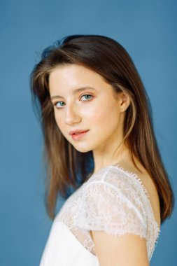 Parlak mavi ve kırmızı zemin üzerine güzel bir gelin portresi. Minimalist beyaz elbise.