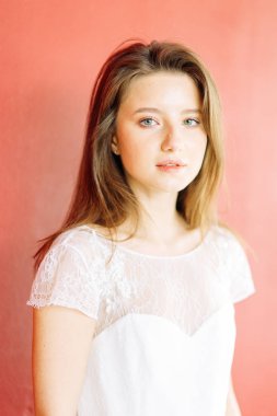 Parlak mavi ve kırmızı zemin üzerine güzel bir gelin portresi. Minimalist beyaz elbise.