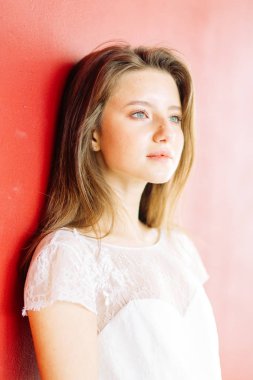 Parlak mavi ve kırmızı zemin üzerine güzel bir gelin portresi. Minimalist beyaz elbise.