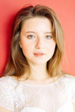 Parlak mavi ve kırmızı zemin üzerine güzel bir gelin portresi. Minimalist beyaz elbise.