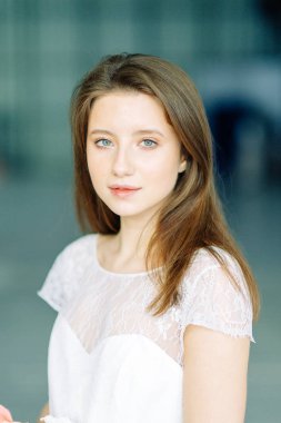 Parlak mavi ve kırmızı zemin üzerine güzel bir gelin portresi. Minimalist beyaz elbise.