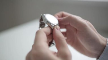 Metal saatin zamanında ayarlanması. Makro çekim ve çelik seyretmek eller.