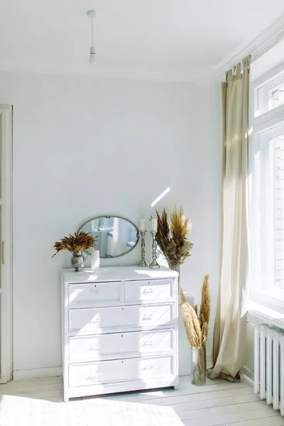 Minimalism in the interior decor. Bright modern interior with dried flowers.