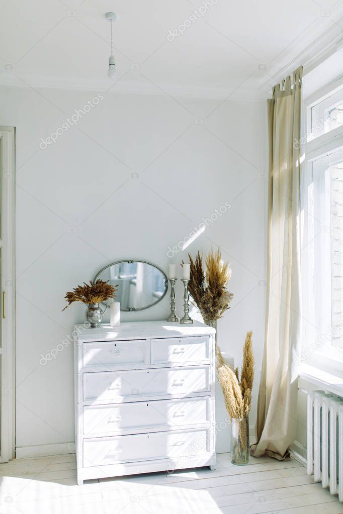 Minimalism in the interior decor. Bright modern interior with dried flowers. 