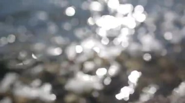 Su üzerinde parlama, bokeh dalgaları. Akan suyun nötr arka planı.