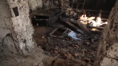 Savaştan sonra gibi terkedilmiş bir ev. Zeminde çöp ile harap bir oda ve duvarlar delikler.