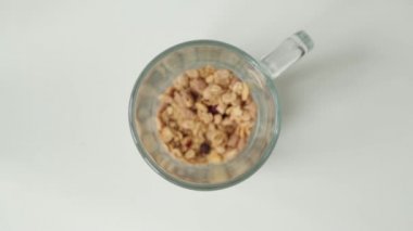 Kahvaltıiçin Granola, yemek pişirmek. Bir kupa içine yulaf lapası dökme.