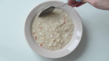 Kahvaltı için bir tabakta yulaf ezmesi. Kaynayan su ile hazırlanması ve demlenmesi.