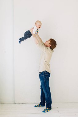  Stüdyoda fotoğraf çekimi, mutlu ebeveynler. Çocuk ile beyaz bir arka plan üzerinde genç aile.