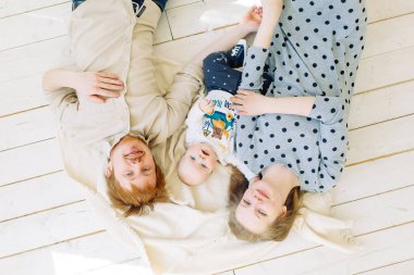  Stüdyoda fotoğraf çekimi, mutlu ebeveynler. Çocuk ile beyaz bir arka plan üzerinde genç aile.