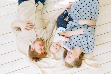  Stüdyoda fotoğraf çekimi, mutlu ebeveynler. Çocuk ile beyaz bir arka plan üzerinde genç aile.