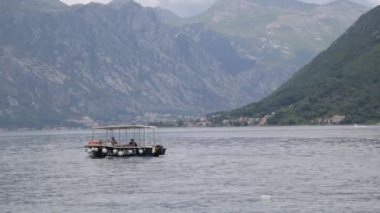Dalgalar üzerinde sallanan balıkçı teknesi. Karadağ'da manzara lar ve deniz, balıkçılık.