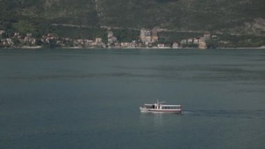Dalgalar üzerinde balıkçılık ve turistik yat parçaları. Karadağ'da deniz ve manzara.