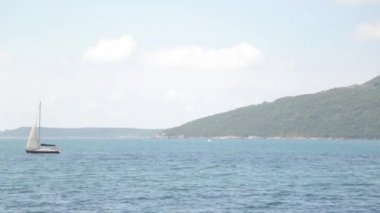 Dalgalar üzerinde balıkçılık ve turistik yat parçaları. Karadağ'da deniz ve manzara.