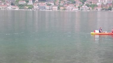 Kotor Körfezi'nde kürekçiler kayak. Karadağ'da rekabet ve turizm tatilleri.