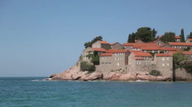 Sveti Stefan adasının pitoresk sahili. Dağdan eski kentin atmosferik turistik görünümleri.