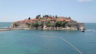 Sveti Stefan adasının pitoresk sahili. Dağdan eski kentin atmosferik turistik görünümleri.