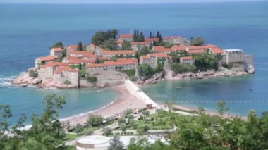 Sveti Stefan adasının pitoresk sahili. Dağdan eski kentin atmosferik turistik görünümleri.