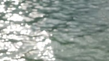 Kıyıya yakın deniz suyunda güneş parlaması. Demirde iskele ve çelik kolları sudan çıkmak için Karadağ'da.