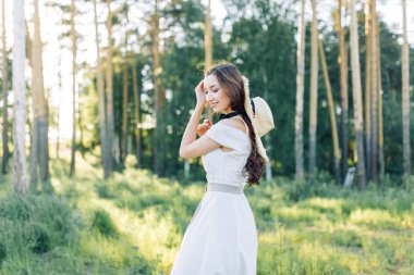 Yaz parkta yürür. Ormanda yürüyen sevimli romantik kız. 