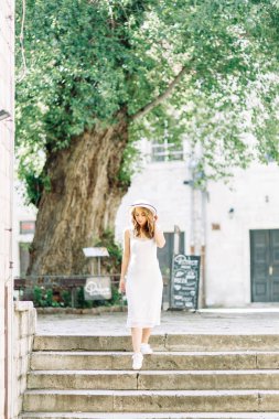 Kotor, Karadağ sokaklarında yaz fotoğraf çekimi. Beyaz elbise ve şapka lı güzel kız. 