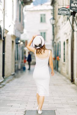 Kotor, Karadağ sokaklarında yaz fotoğraf çekimi. Beyaz elbise ve şapka lı güzel kız. 
