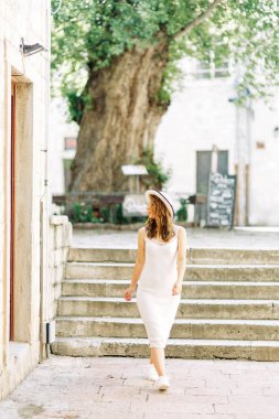 Kotor, Karadağ sokaklarında yaz fotoğraf çekimi. Beyaz elbise ve şapka lı güzel kız. 