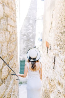 Kotor, Karadağ sokaklarında yaz fotoğraf çekimi. Beyaz elbise ve şapka lı güzel kız. 