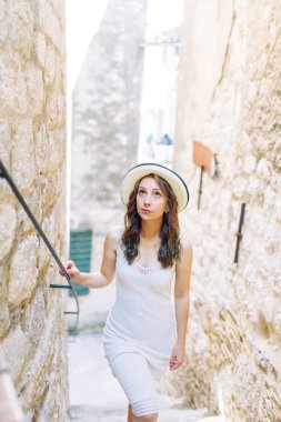 Kotor, Karadağ sokaklarında yaz fotoğraf çekimi. Beyaz elbise ve şapka lı güzel kız. 