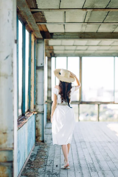 夏季图像和浅色连衣裙 一个美丽的女孩在日落时在一个废弃的建筑物的肖像 — 图库照片