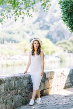 Kotor, Karadağ sokaklarında yaz fotoğraf çekimi. Beyaz elbise ve şapka lı güzel kız. 
