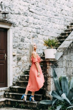  Kırmızı elbiseli güzel bir kız. Kotor akşam sokaklarında fotoğraf çekimi.