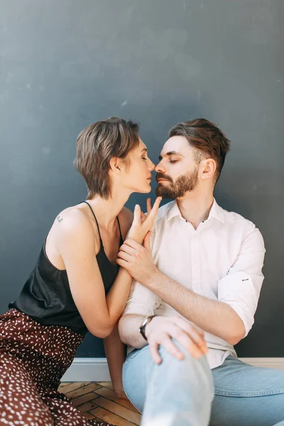 Stylish couple on the bed. Beautiful love story in the dark interior of the Studio.