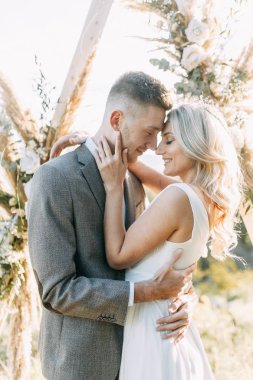 Gün batımında şık bir çift. Üçgen kemerli düğün töreni. 