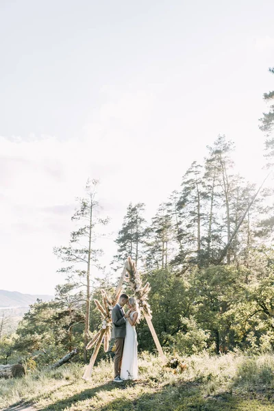 Casal Elegante Pôr Sol Cerimônia Casamento Com Arco Triangular — Fotografia de Stock