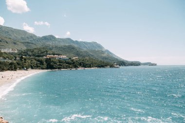 Karadağ'da kum ve şezlonglu turistik plaj. Sveti Stefan adası yakınındaki pitoresk sahil. 