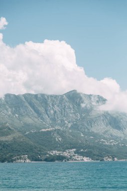 Karadağ'da kum ve şezlonglu turistik plaj. Sveti Stefan adası yakınındaki pitoresk sahil. 