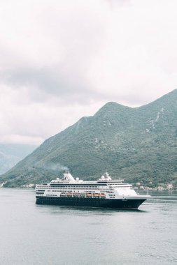 Karadağ'da sakin bir denizde turist gemisi. Kotor Körfezi'nde modern bir yolcu gemisi. 
