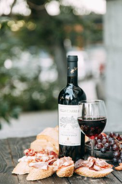 Bruschettes ve prosciutto ile piknik. İtalya'da bir bardak kırmızı şarap. 
