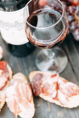 Bruschettes ve prosciutto ile piknik. İtalya'da bir bardak kırmızı şarap. 