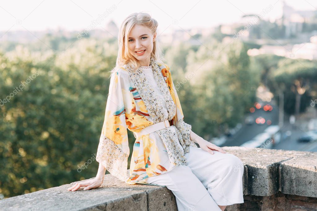 Beautiful sunset in Rome with panoramic views. Girl blogger in Italy in orange garden. 