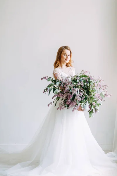 ヨーロッパスタイルの結婚式 ライラックの花束とスタジオでスタイリッシュなトレンディな花嫁 — ストック写真