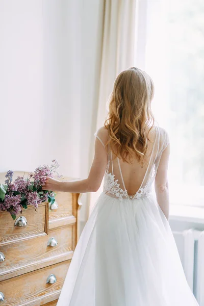 Wedding in European style. Stylish trendy bride in the Studio with a bouquet of lilacs.