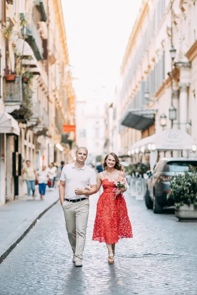 Stylish loving couple walking and laughing. Wedding shooting on the streets of Rome, Italy.