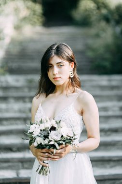 Gün batımı ile doğada uzun elbiseli gelin. Güzel sanatlar Avrupa tarzında şık bir düğün. 