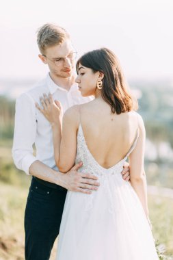 Gün batımında dışarıda mutlu bir çift. Güzel sanatlar Avrupa tarzında şık bir düğün. 